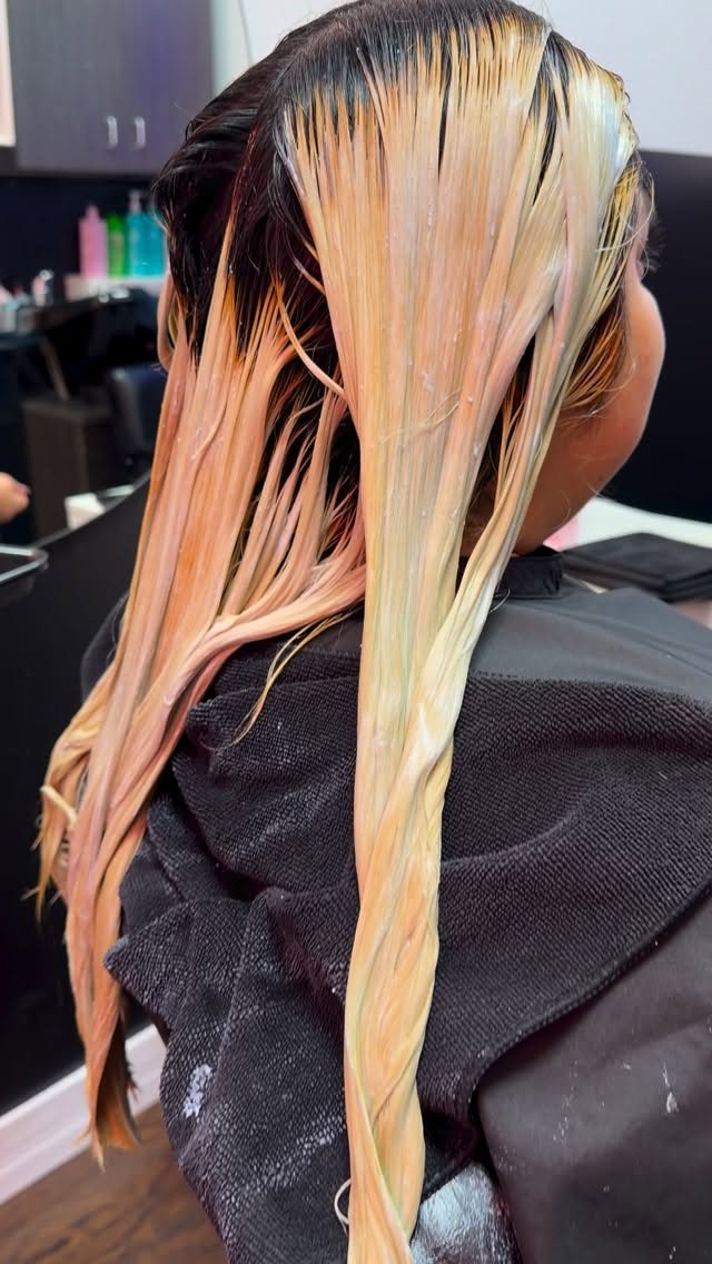 In progress color correction lifting red violet hair to blonde at Mirian May salon in Glendale, CA